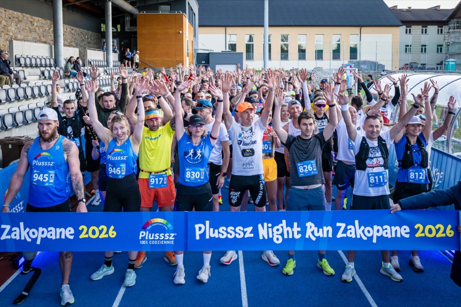 Runners cheering with hands up at the start line