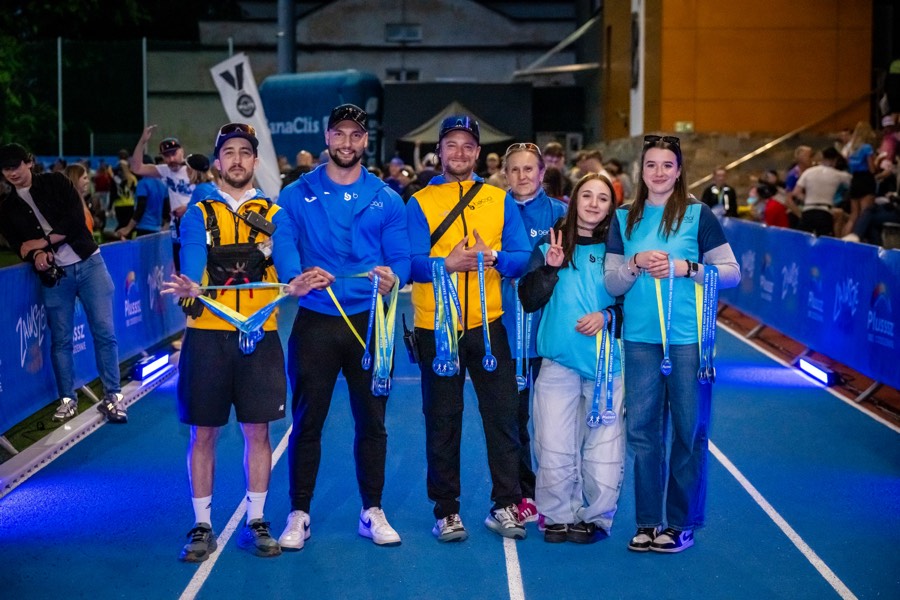 Volunteers and runners with medals at night